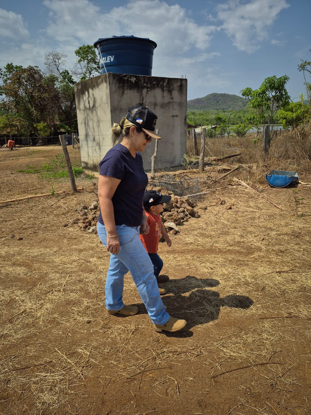 Marlupe caminhando com uma criança no campo